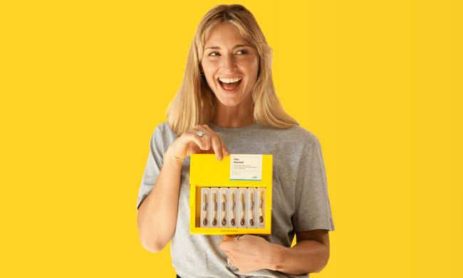 Vitl dna test in a woman's hand on a yellow background